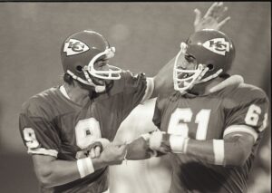 Kansas City Chiefs quarterback Billy Kenney (9) celebrates with his teammate nose tackle Don Parrish (61) during a 1980 NFL game.